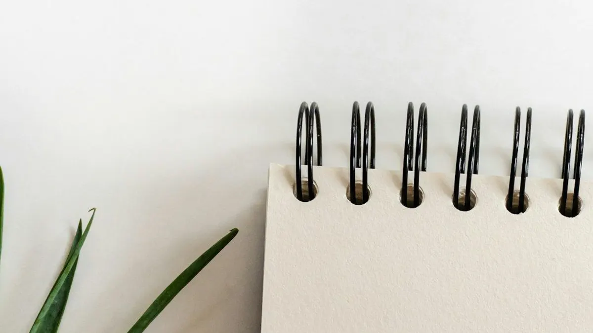 開いたノートとペン。収支を書き出すイメージ。