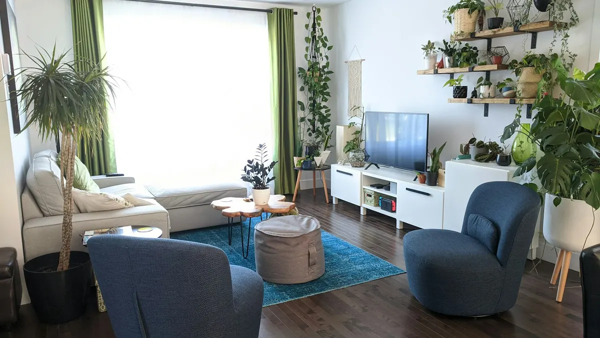 緑の植物と青い椅子のある明るい部屋。落ち着いて見直す時間のイメージ。