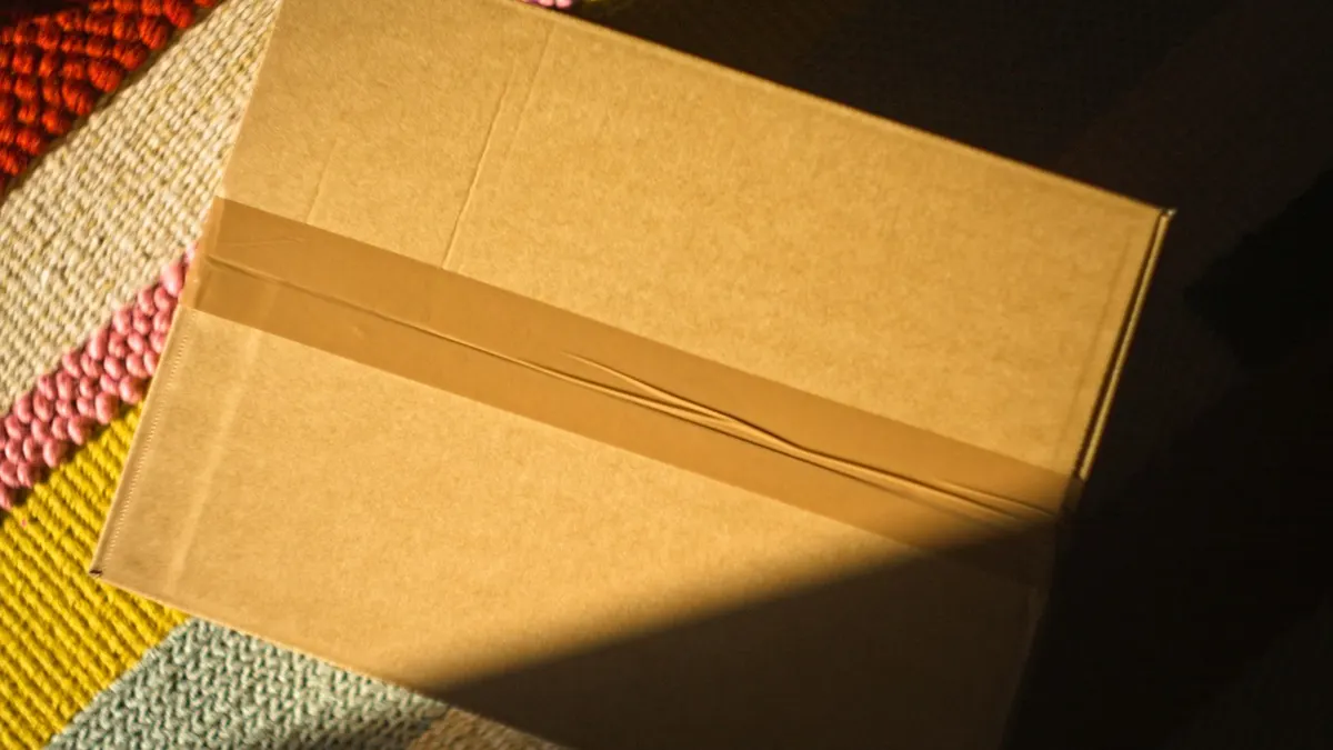 カラフルな敷物の上に置かれた梱包済みの小箱。回転の早い商品を発送する準備のイメージ。