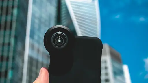 店頭でスマートフォンを取り出し、価格の推移を調べている手元