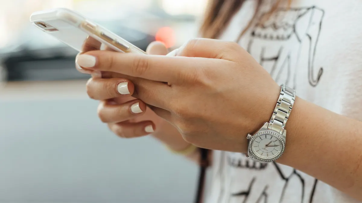 スマートフォンに届いた重要通知を確認し、緊張している場面のイメージ。