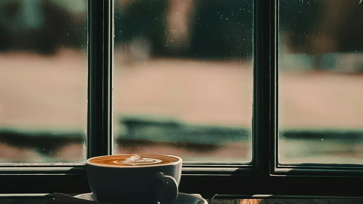 窓辺の机とコーヒー。落ち着いて振り返るシーン。
