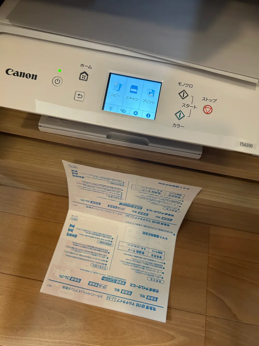 インクジェットプリンターの前に、印刷が終わった送り状用紙が置かれている写真。