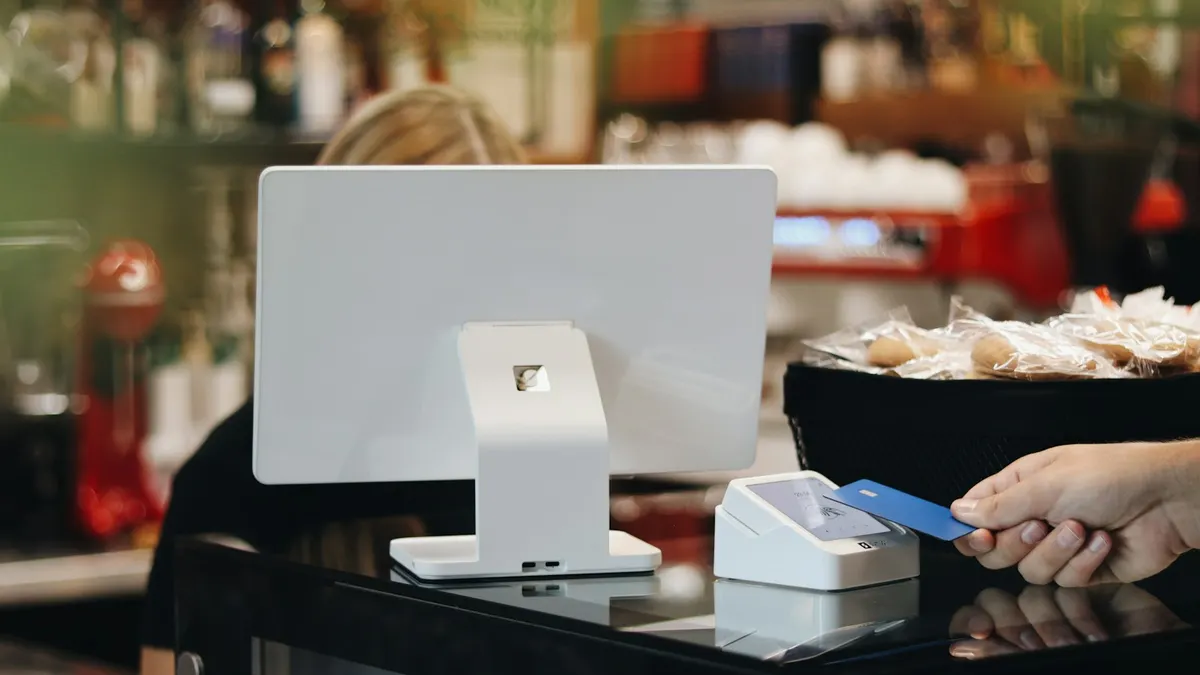 店員のいるレジカウンターで在庫を確認しているイメージ。