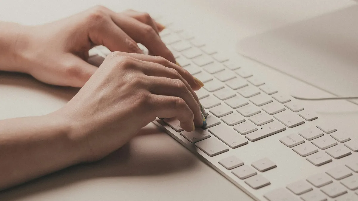 ノートパソコンのキーボードに手を置き、電脳リサーチをしているイメージ。