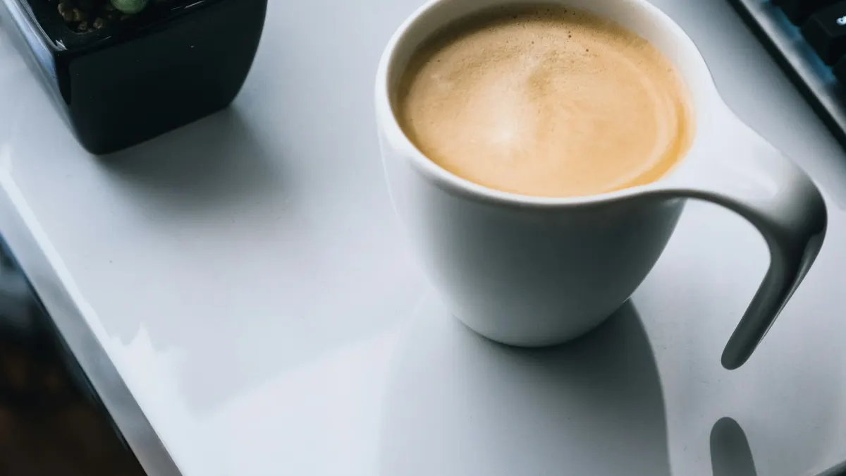 コーヒーを置いた机で、落ち着いてリサーチしているイメージ。