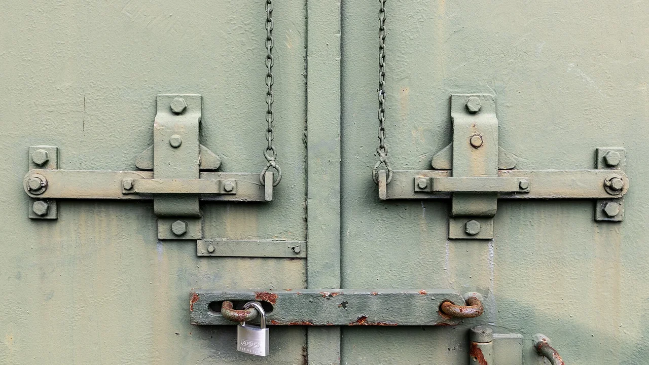 南京錠がかかったドアのクローズアップ。iDeCoの資産ロックイメージ。