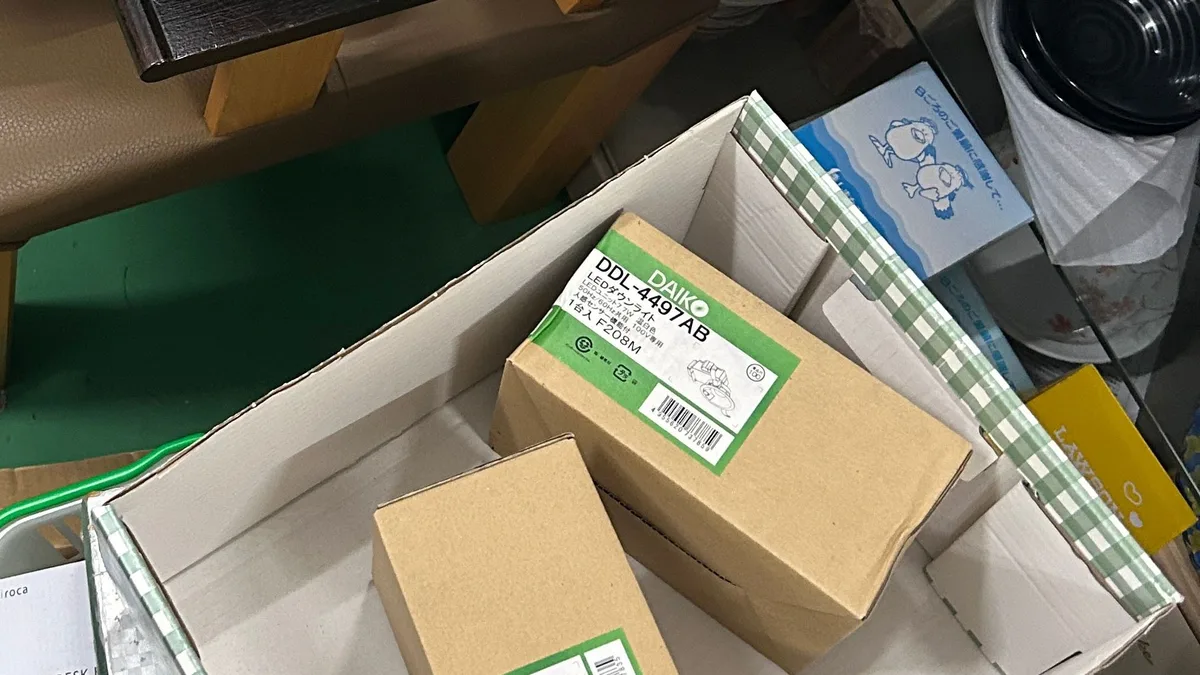 リサイクルショップの店内。DAIKO DDL-4497ABと書かれたLEDダウンライトの箱が、買い物カゴと段ボールに積まれている