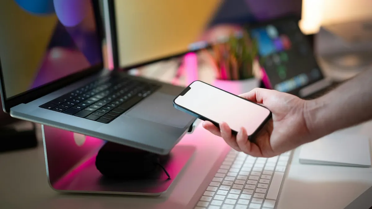 何も表示されていないスマートフォンを手に持っている様子