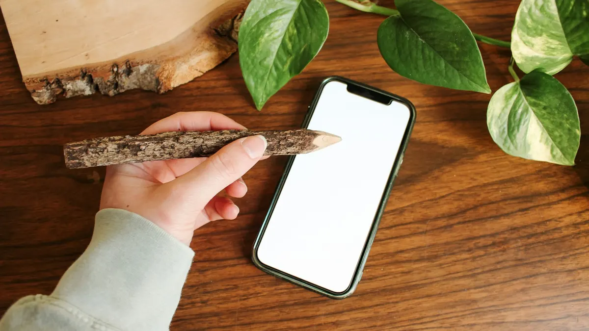 スマートフォンの画面を指で操作している手元