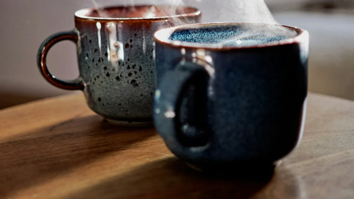 向かい合った2つのコーヒーカップ。1対1の対話のイメージ。