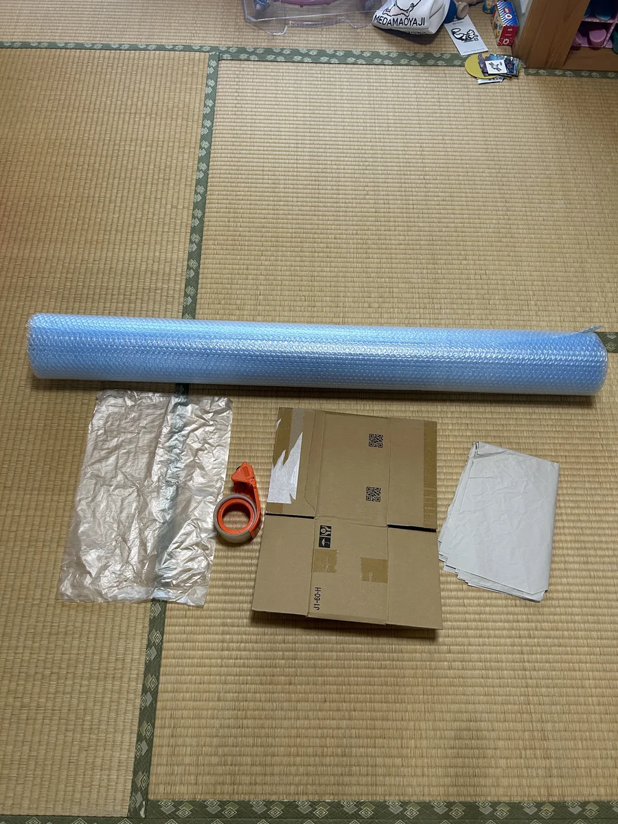 業務用プチプチのロールと無料調達した段ボールを並べたイメージ