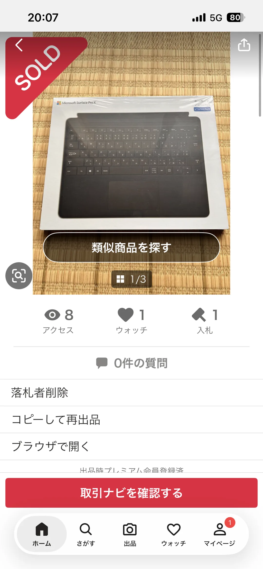 ヤフオク!の出品者画面の実画面。畳の上に置かれた新品未開封のMicrosoft Surface Pro X用キーボードの箱の写真に赤いSOLDリボンが重なり、アクセス8・ウォッチ1・入札1、0件の質問、「取引ナビを確認する」ボタンが表示されている。