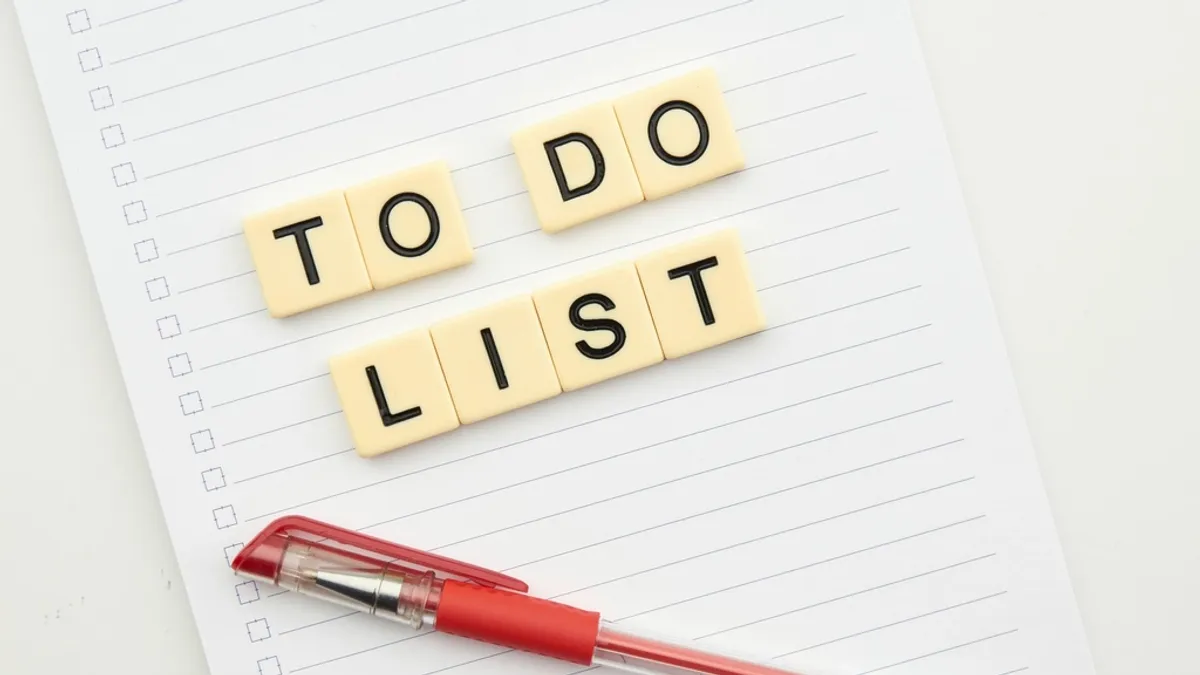 チェックボックス付きの罫線ノートに「TO DO LIST」の文字ブロックが並び、赤いボールペンが置かれている。