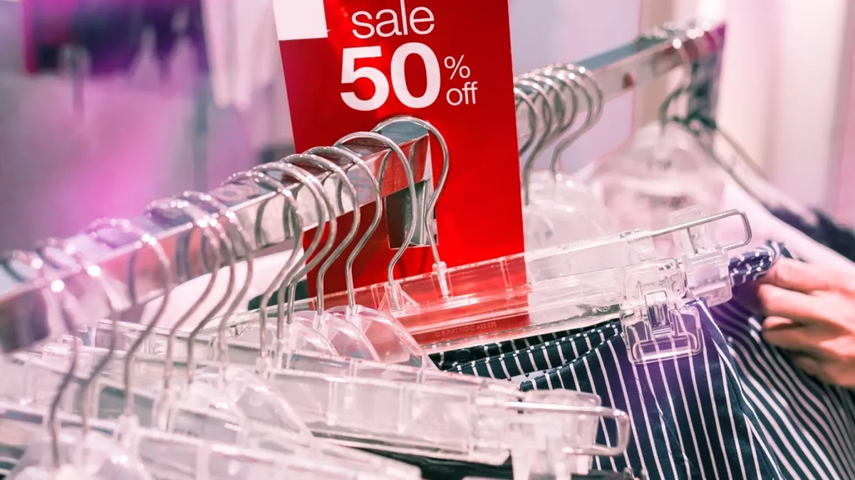 衣料品のハンガーラックに差された「sale 50% off」の赤い札。