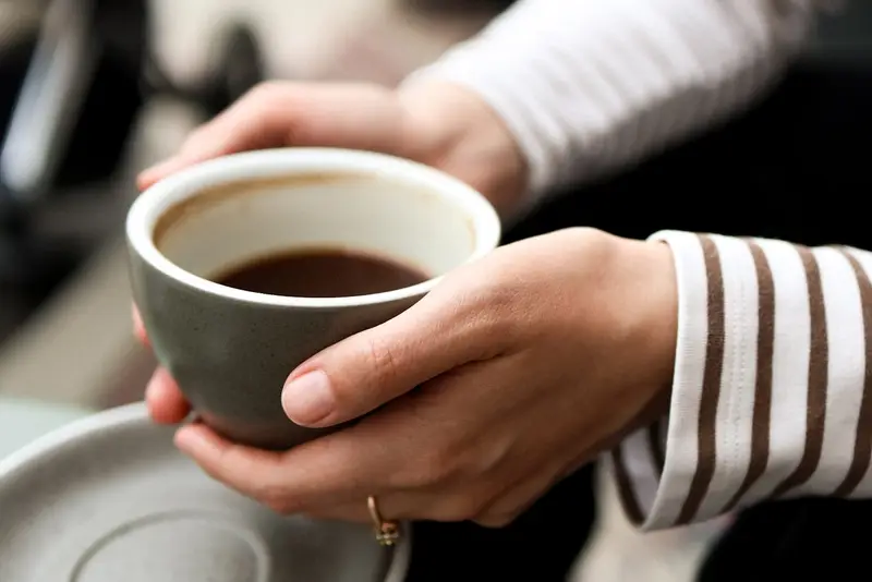 コーヒーカップと、少し手を止めて一息つく時間。暖色の光。