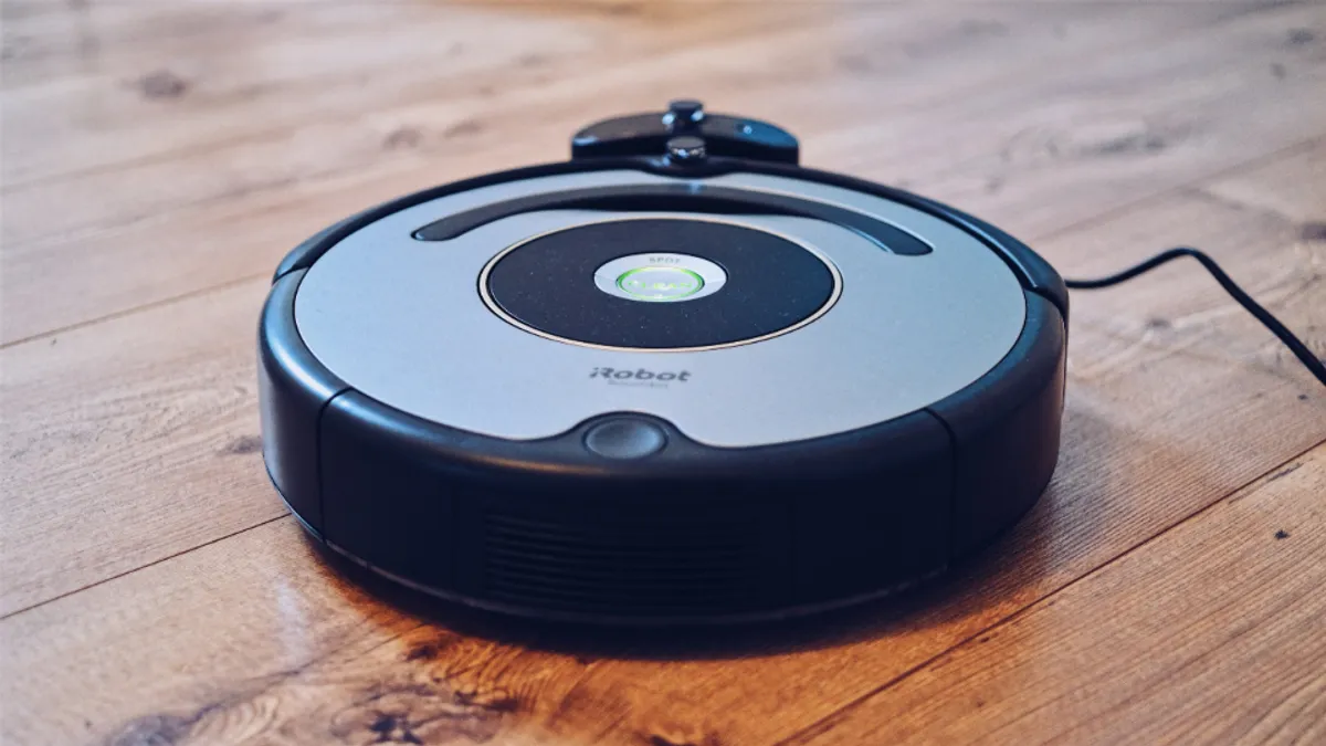 木のフローリングの上に置かれた円盤型のロボット掃除機