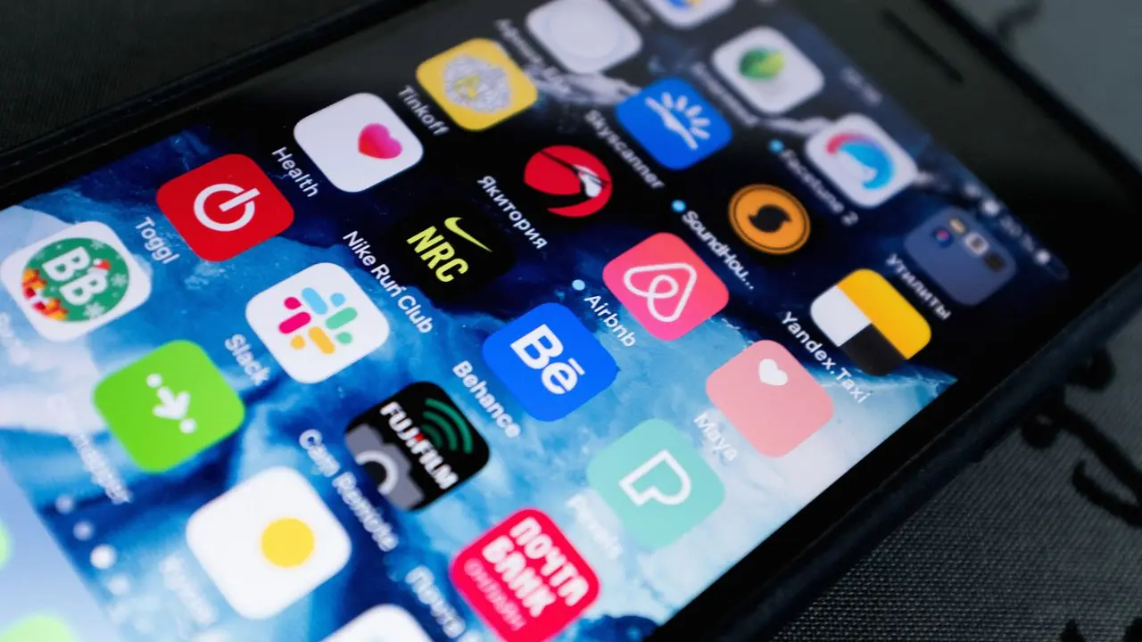 2台のスマートフォンを並べて比較している手元。楽天とメルカリの価格比較のイメージ。