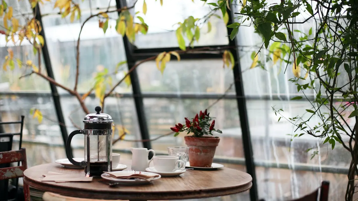 窓辺の片付いた机とコーヒー。落ち着いた朝のまとめのシーン。
