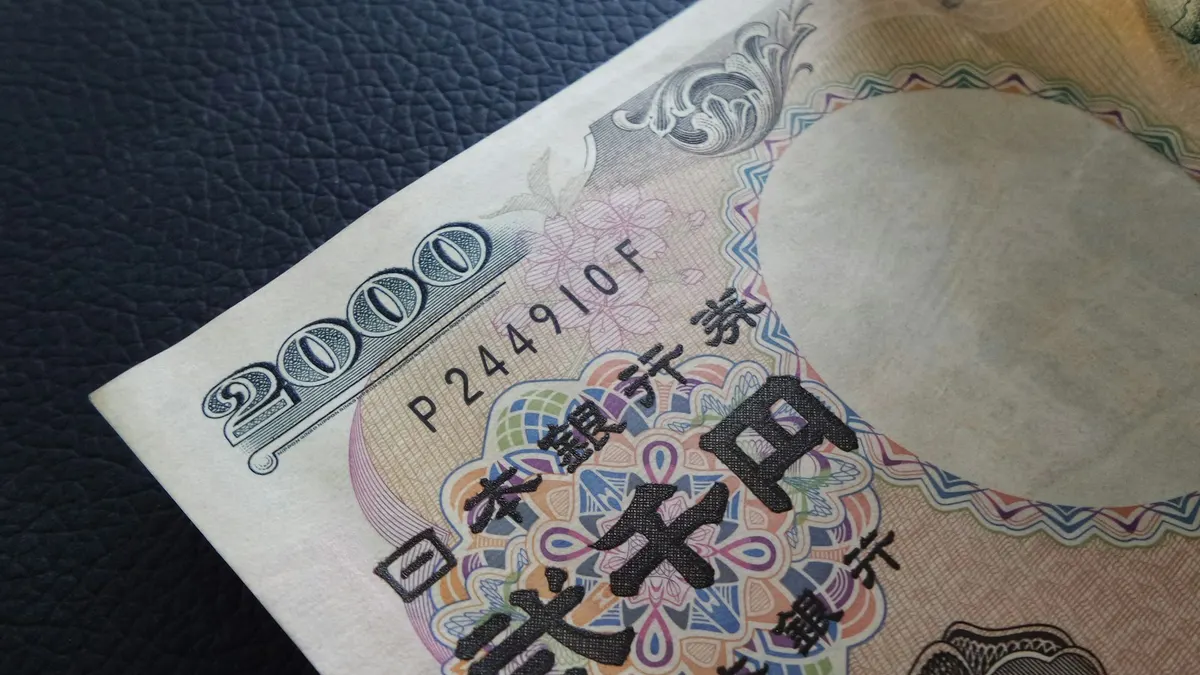 日本銀行券の紙幣を斜め上から接写した写真。「2000」の額面数字と「日本銀行券」「弐千円」の文字、記番号が読み取れる。