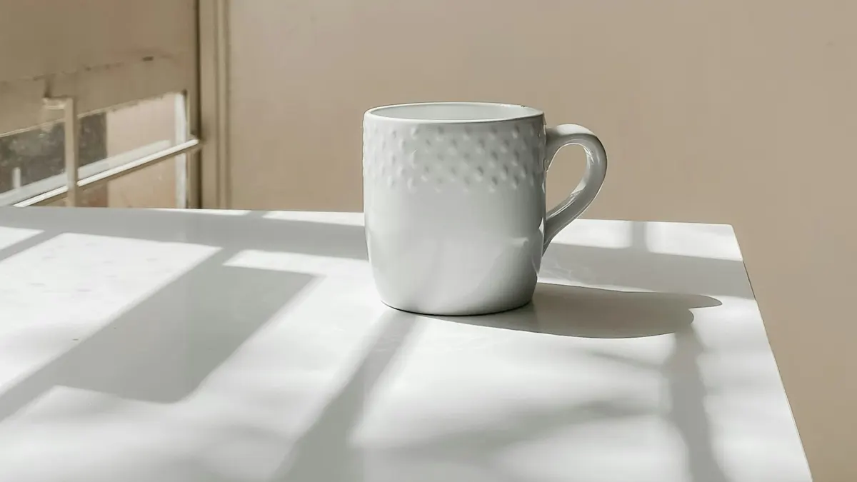 窓辺のマグカップと落ち着いた光。振り返りのシーン。