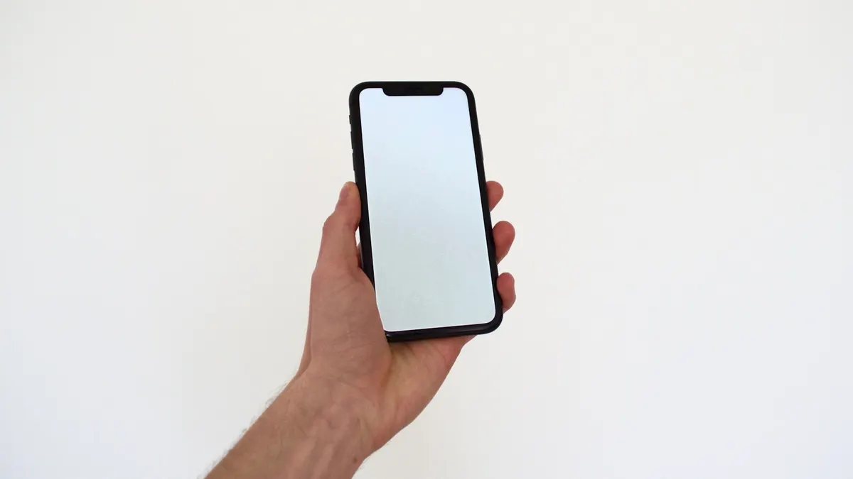 スマートフォンで売上・入金の通知を確認している手元。落ち着いた室内。