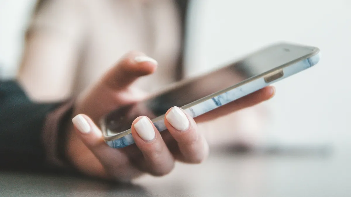 スマートフォンで入金・残高を確認しているイメージ。