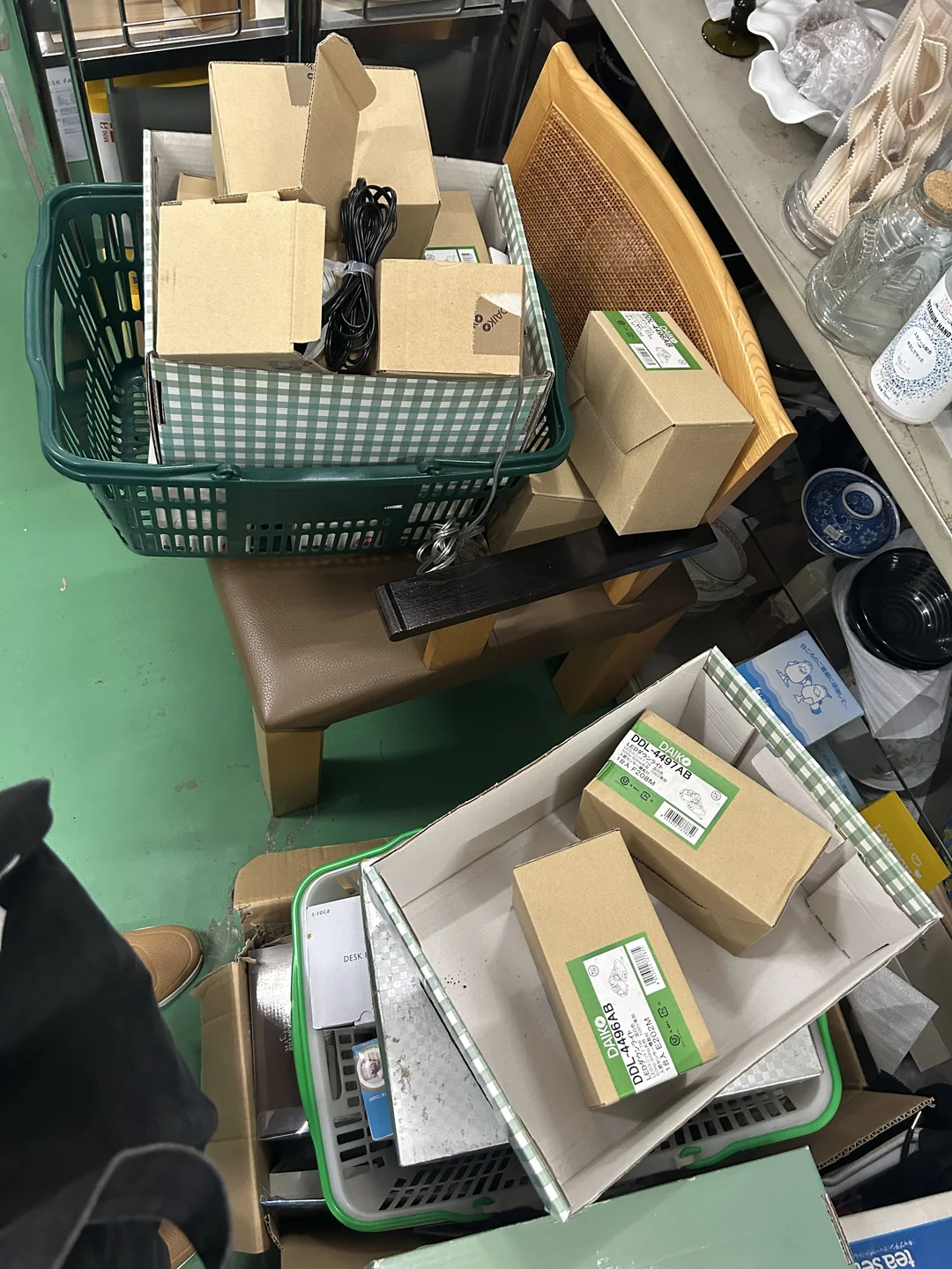 リサイクル店の床に置かれた買い物かご。DAIKO DDL-4496AB/DDL-4497ABと印字された未使用のダウンライトの箱が数個ずつ入っている