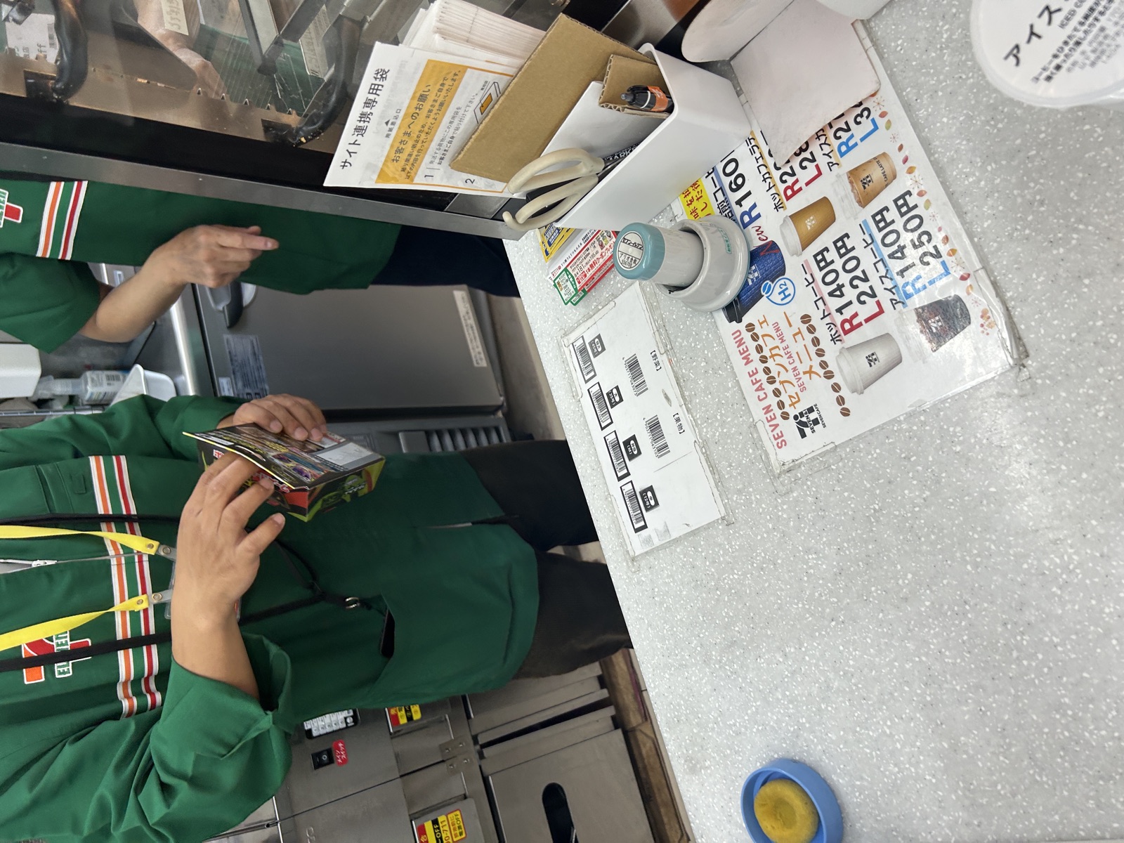 レジで2店舗分の商品を会計している様子（店員さんの顔は識別できないアングル）