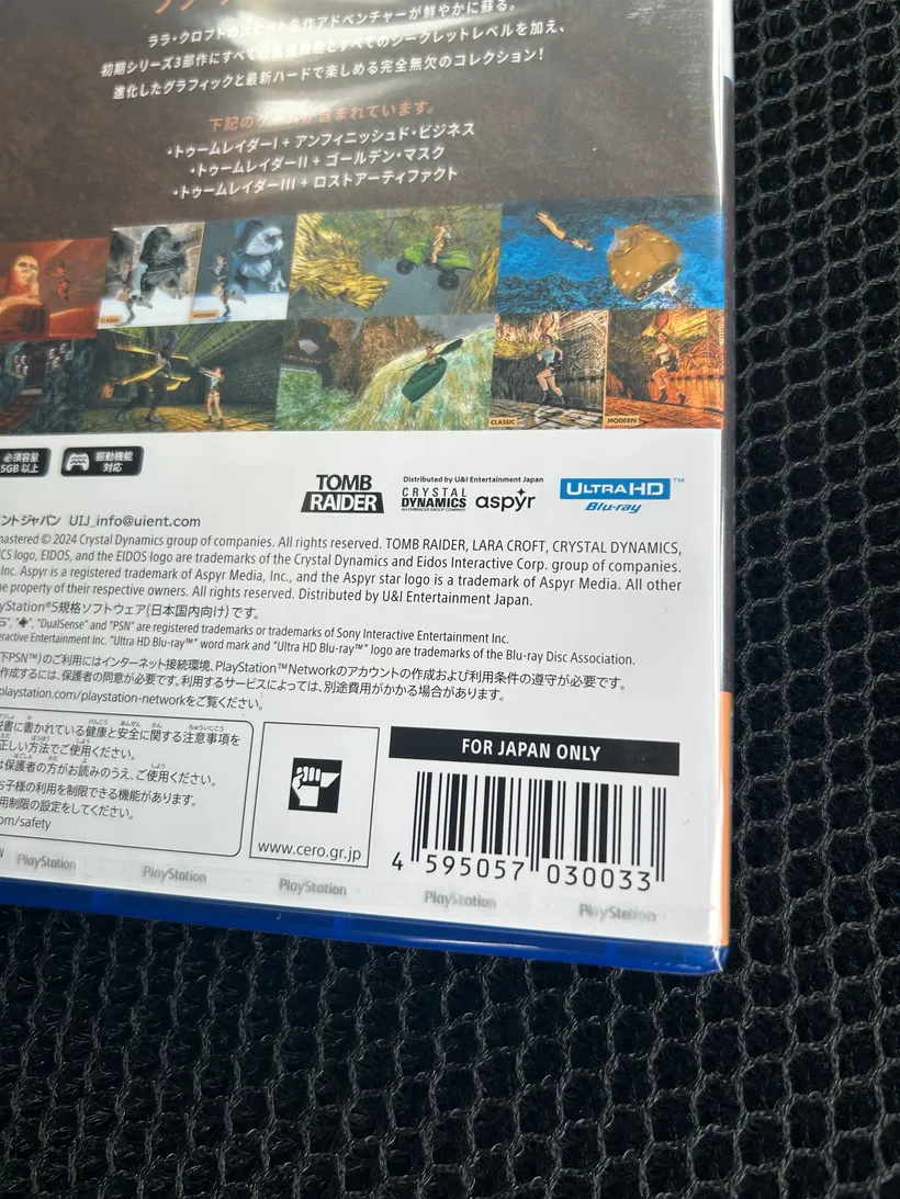 PS5『トゥームレイダーI-IIIリマスター』の裏面。収録3作の紹介とバーコード。車のシートの上で撮影。