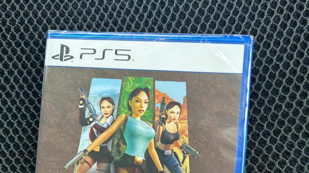 車のシートの上に置かれた、シュリンク未開封のPS5『トゥームレイダーI-IIIリマスター』のパッケージ。TSUTAYAで¥1,100で仕入れた実物を、買ったその場で撮影したもの。