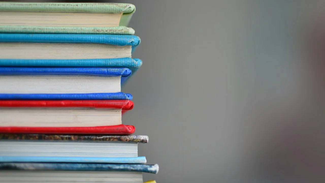 カラフルな本が積み重なっている。学習と知識のイメージ
