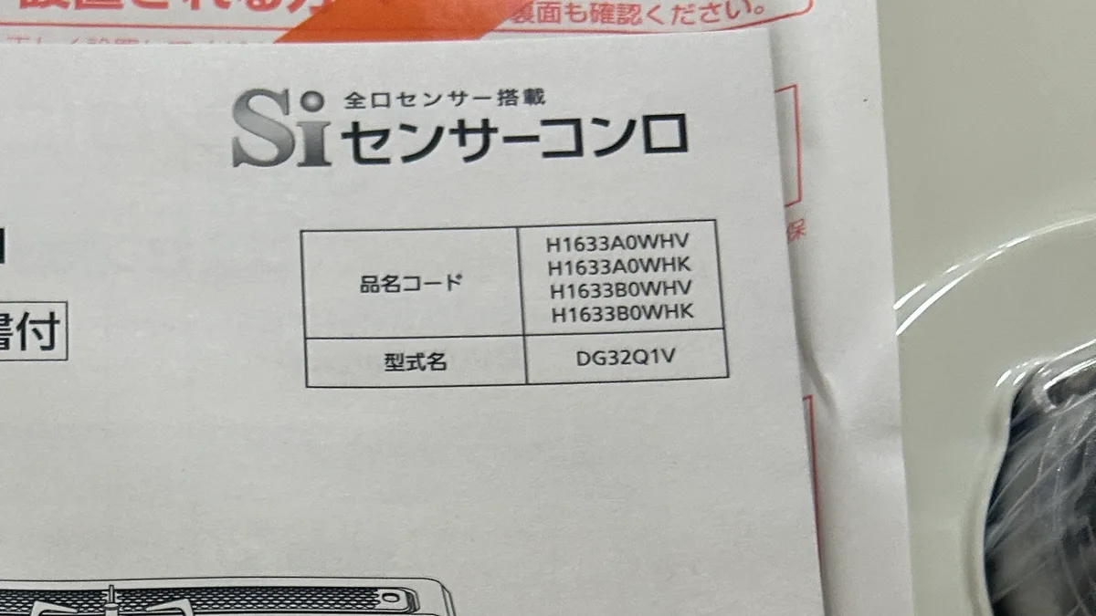 取扱説明書の表紙のアップ。「Si 全口センサー搭載 センサーコンロ」のロゴの下に表があり、「品名コード：H1633A0WHV／H1633A0WHK／H1633B0WHV／H1633B0WHK」「型式名：DG32Q1V」と印刷されている。